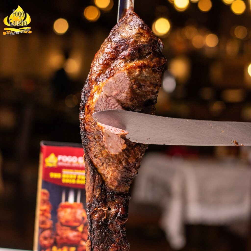 Grilled beef steak being sliced with a long knife at the best Brazilian restaurant in Nairobi.